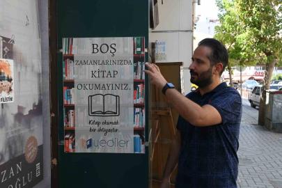 Dükkan önüne astıkları afiş vatandaşlara okuma alışkanlığı kazandırıyor